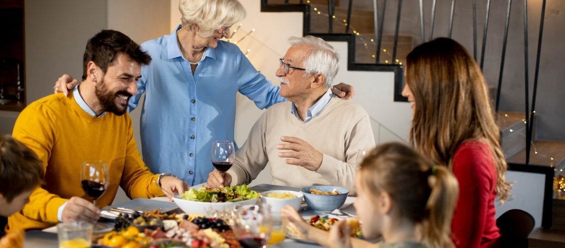 Happy family having a dinner with red wine at home